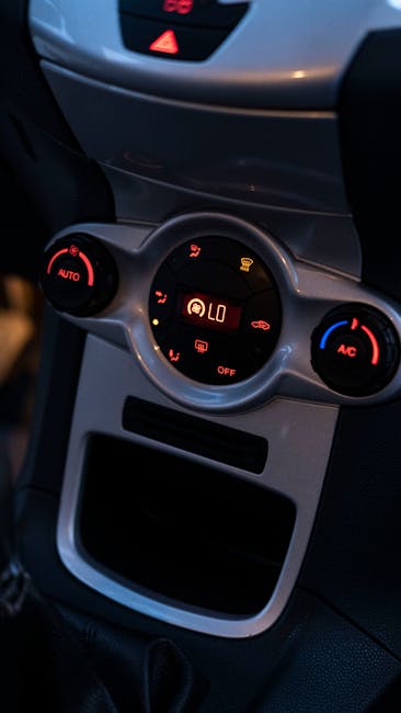 Detailed view of a car's climate control panel, featuring illuminated temperature and air conditioning settings.